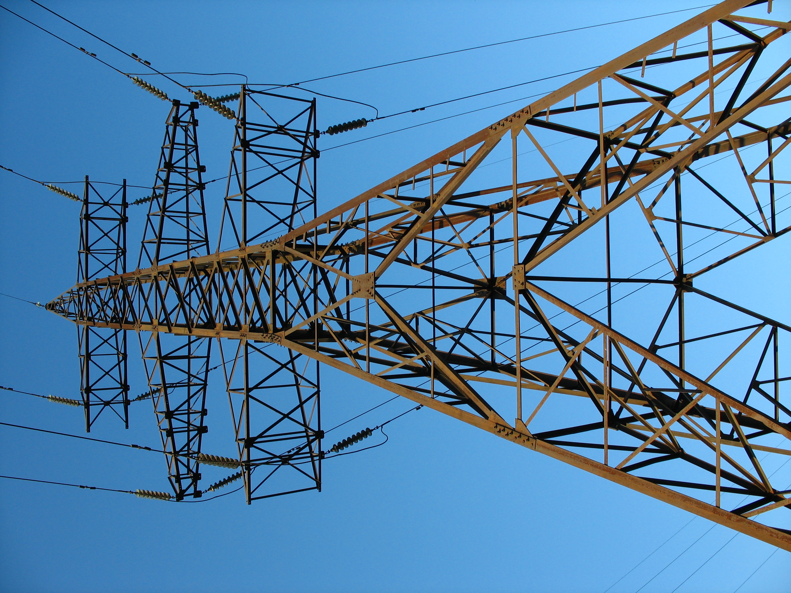 High-voltage transmission tower against blue sky